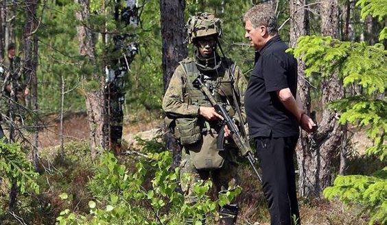 Sotilas juttelee Presidentti Sauli Niinistön kanssa metsässä