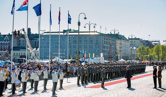 Soittokunta, sotilaita rivissä punaisen maton vieressä ja eri maiden lippuja Helsingissä