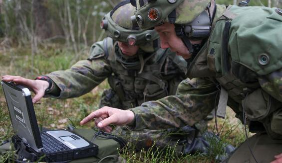 Two soldiers using a computer in the field