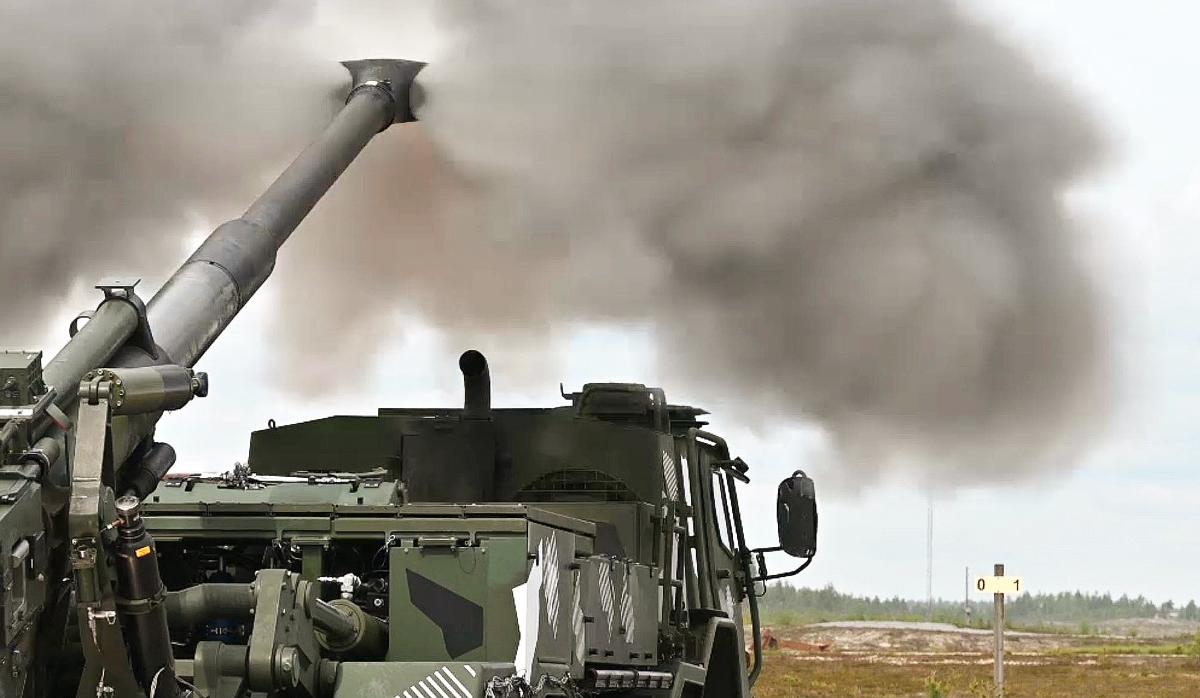 The image shows Patria’s ARVE field gun integrated onto a Sisu all-terrain truck chassis, moments after firing. Smoke is dispersing from the muzzle.