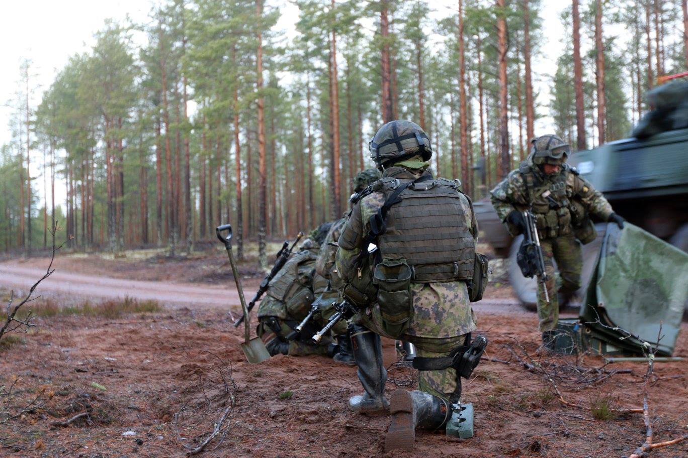 Soldater i skogen under träning.