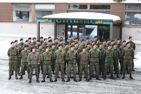 Panssarikoulun etupihalla seisoo 45 nuorta sotilasta, panssarirukkilaisia, riveittäin, keskellä kurssin priimus miekka kädessä.