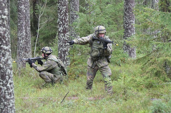 Reserviläisiä harjoituksessa maastossa syksyllä 2021. Kaksi sotilasta, he tähtäävät rynnäkkökiväärillä, taaempi suojaa etummaista.