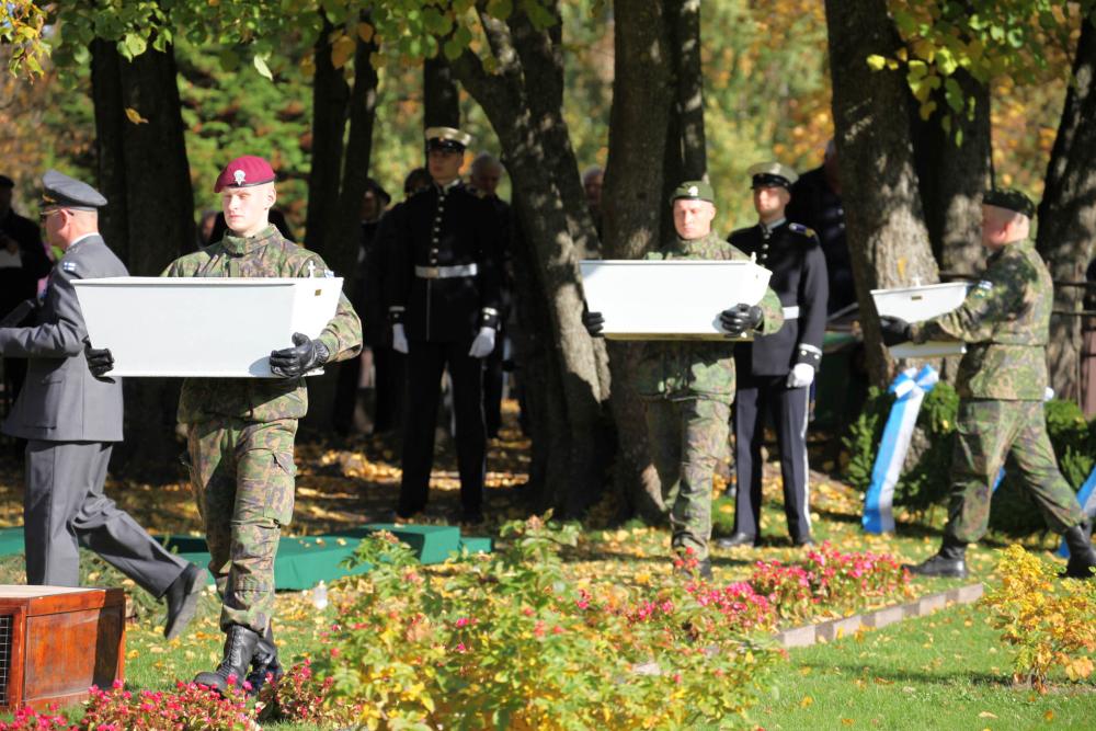 sotilaat kantavat kolmen sankarivainajan arkkuja hautausmaalle