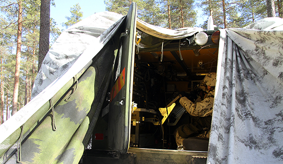 A soldier inside a camouflaged vehicle