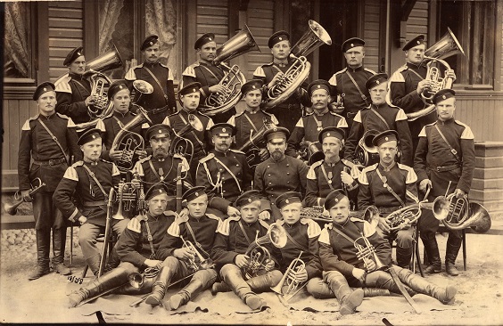 Historiallinen, mustavalkoinen kuva, jossa sotilassoittajia on ryhmäkuvassa soittimiensa kera.