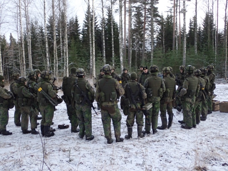 Sotilaita kerääntyneenä kouluttajan ympärille