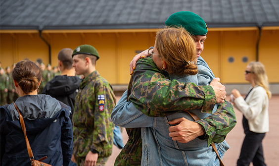 Reserviupseerikoulun pihalla upseerioppilaat tapaavat läheisiään.