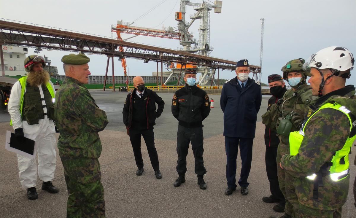 Puolustusvoimain komentaja kenraali Timo Kivinen keskustelee Rauma 21 -paikallispuolustusharjoitukseen osallistuvien viranomaisten ja sotilaiden kanssa Rauman satama-alueella.