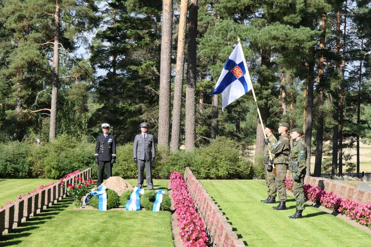 Sankarihautausmaalla Puolustusvoimain lippu ja lippuvartio, sotilaita tekemässä kunniaa ja seppelettä laskemassa.