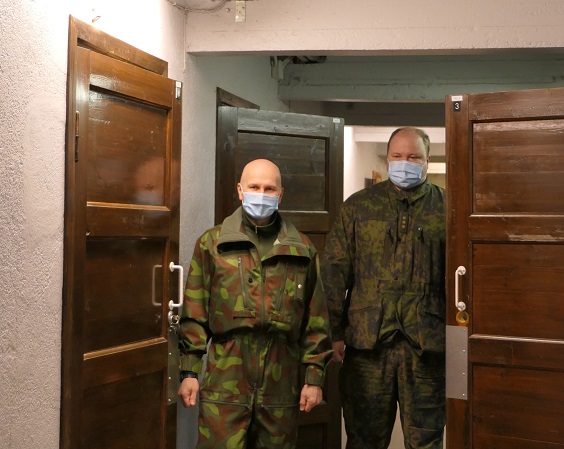 Kaksi sotilasta seisoo käytävällä, ovien vieressä.