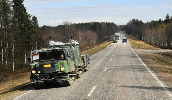 Tela-kuorma-auto ajamassa tiellä, myös muuta liikennettä.