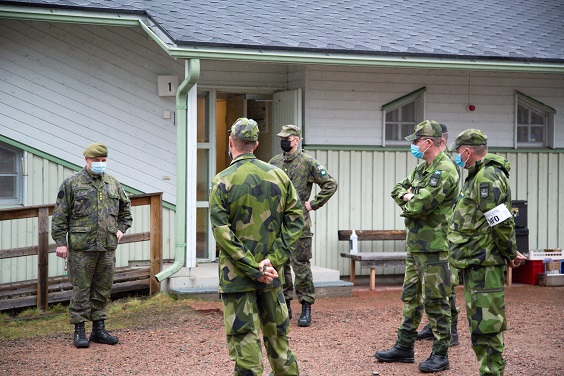 Finnish and Swedish soldiers standing together with masks on their faces.