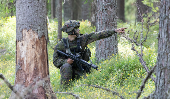 Metsässä upseerioppilas osoittaa kädellä suuntaa RUK:n Yhteistoimintaharjoituksessa