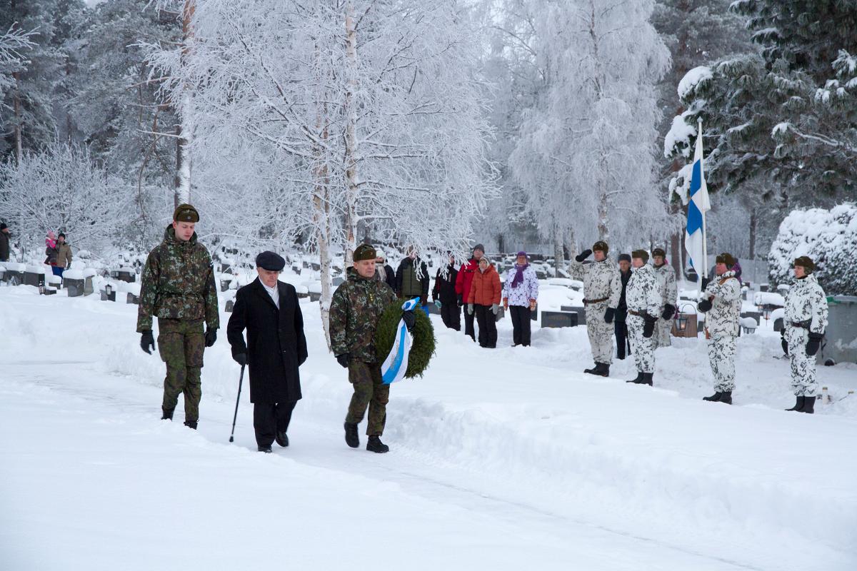 Seppeleenlasku itsenäisyyspäivänä 2017 Sodankylässä. Varusmies, veteraani ja komentaja, taustalla lippuvartio.