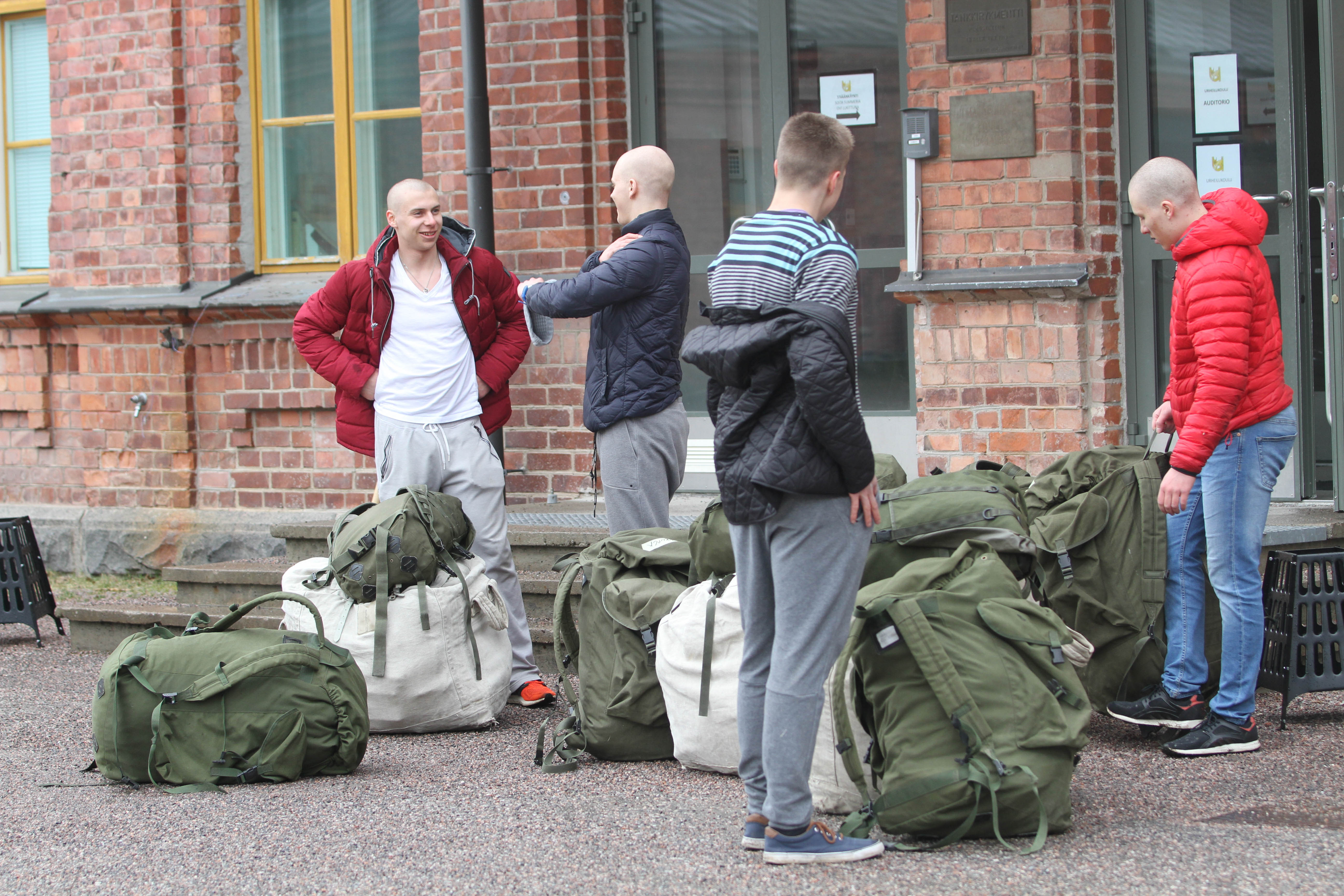 Miehet juttelevat kasarmin vierustalla