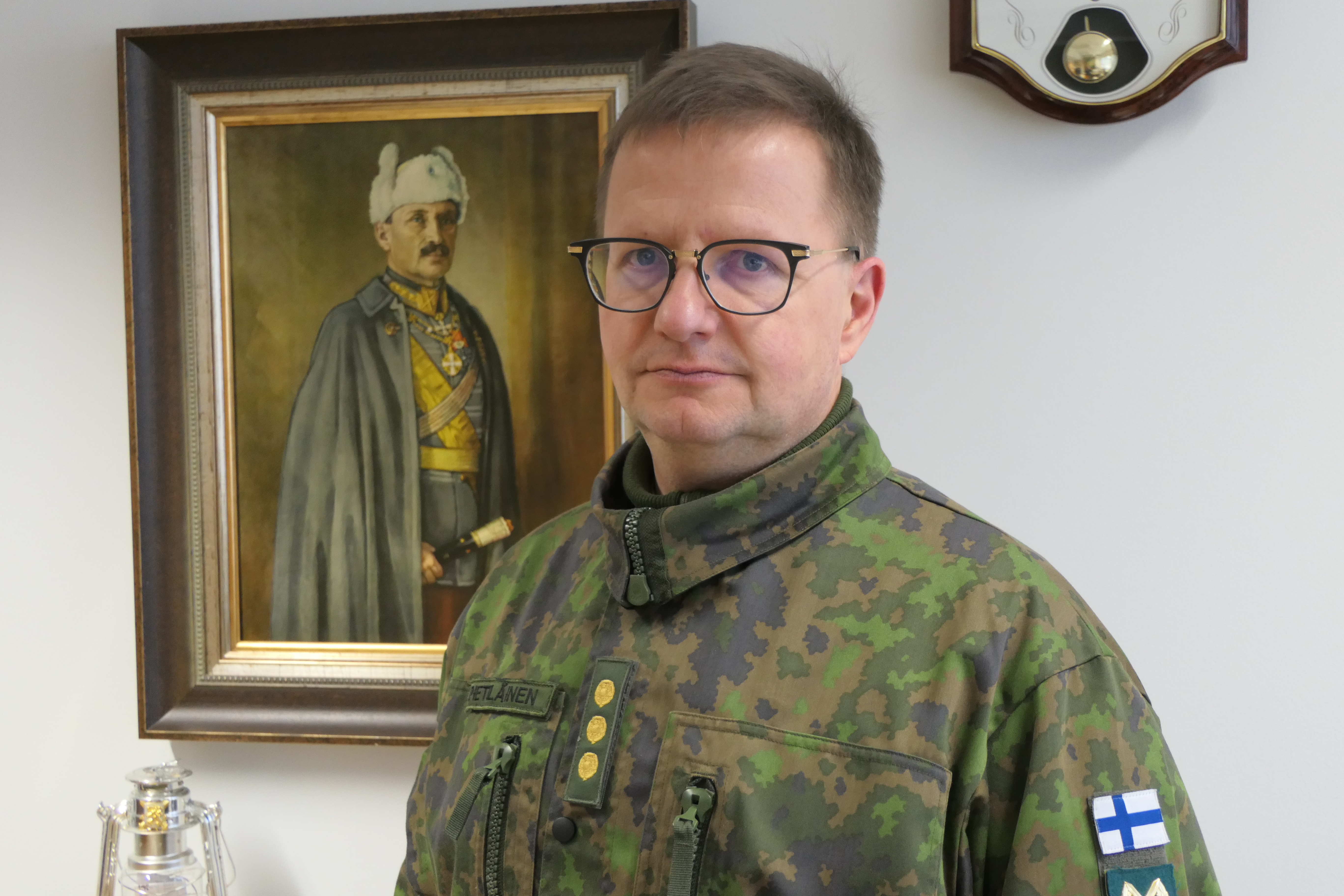 Maasotakoulun johtaja eversti Kari Pietiläinen Mannerheimin taulun/kuvan edessä.