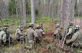 Sotilaat metsässä korkeassa polviasennossa käskynannossa