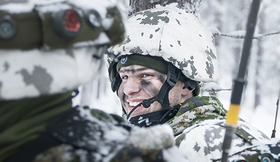 Naurava sotilas lumisessa metsässä