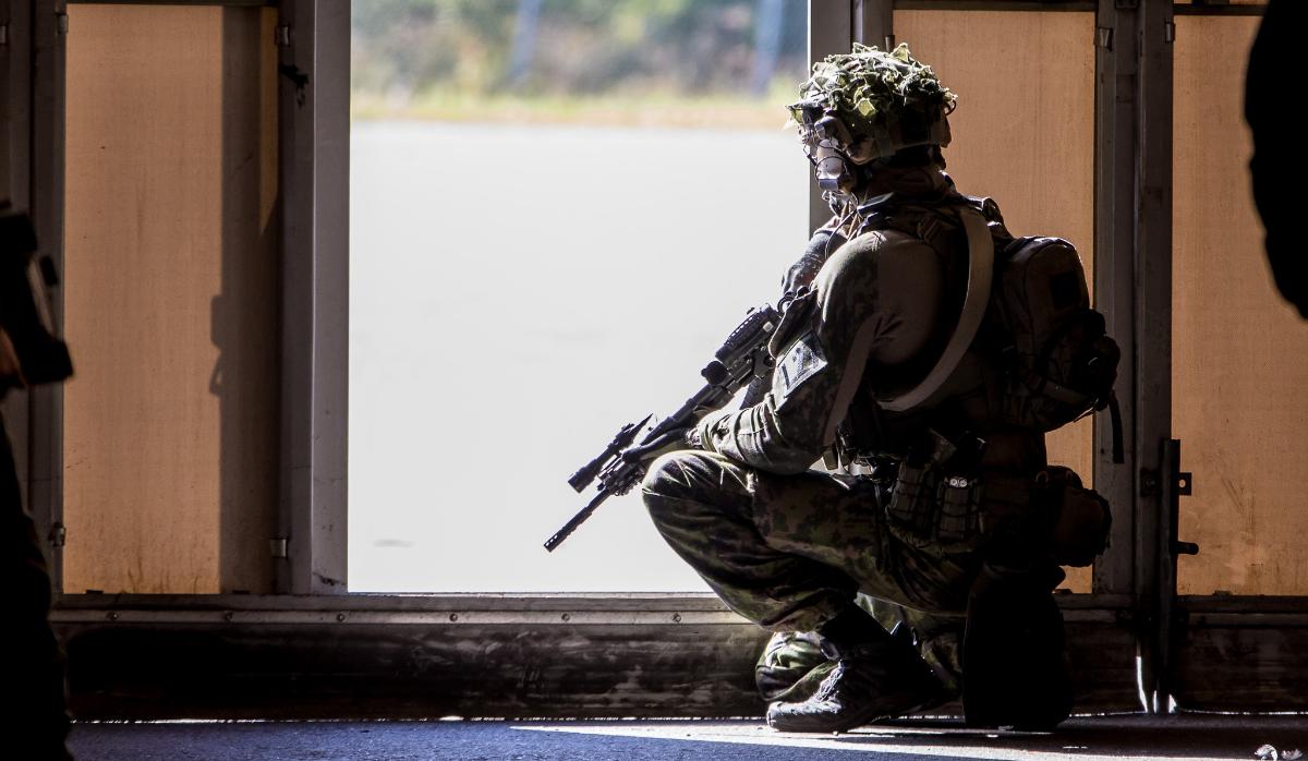 Paikallisjoukkojen sotilas valvoo varastohallin ovea