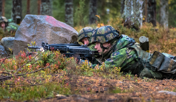 kuva, jossa kaksi henkilöä on tuliasemassa kiven vieressä