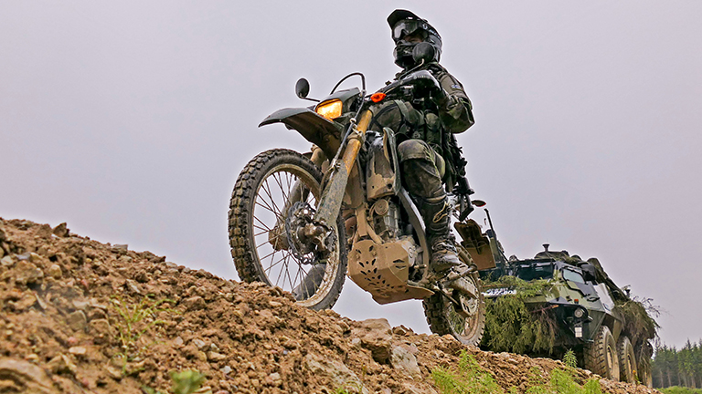 Sotilas ajaa Puolustusvoimien moottoripyörällä