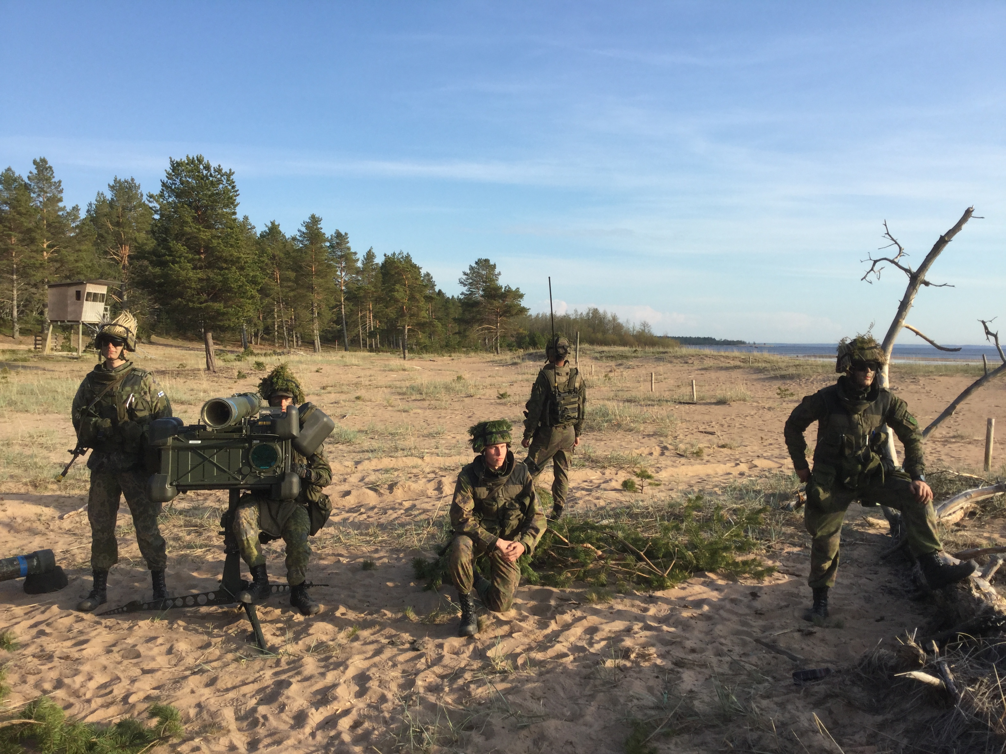 Sotilas tähtää ilmatorjuntaohjuksella istualtaan ja neljä muuta tähystävät