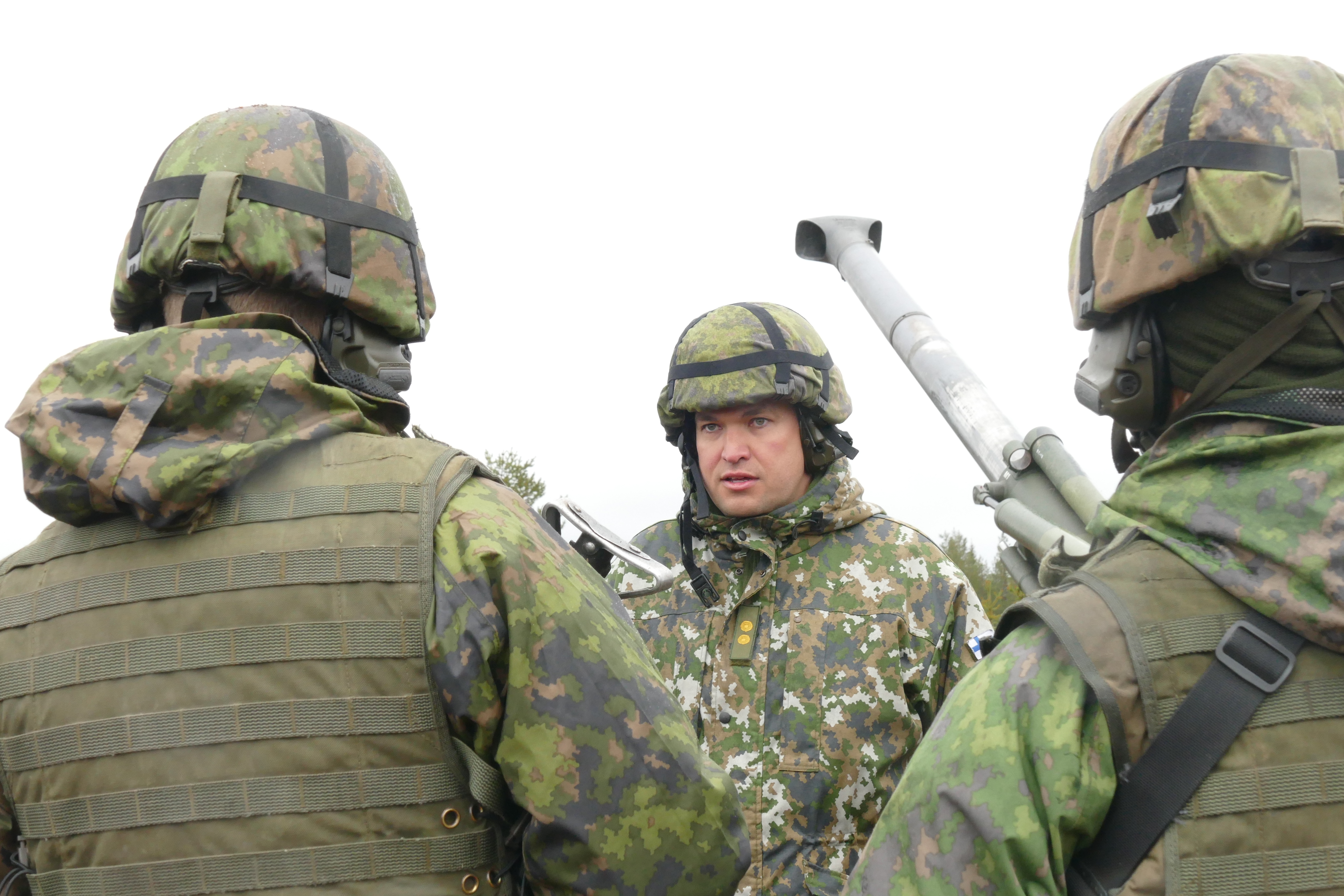 Everstiluutnantti Petri Haataja keskustelee suomalaisten varusmiesten kanssa kenttäkanuunan luona.