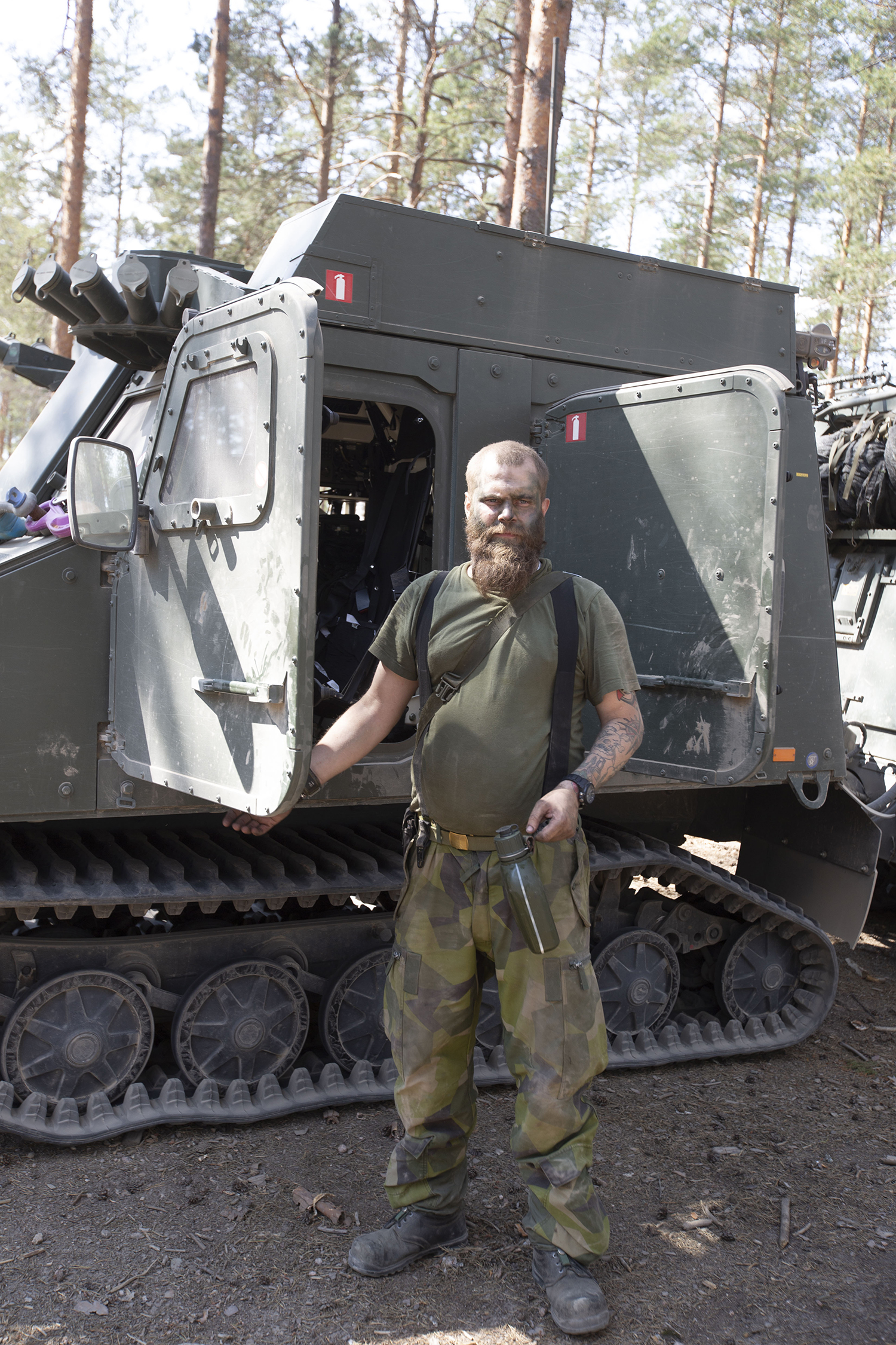 Ruotsalainen sotilas panssaroidun tela-ajoneuvon vierellä