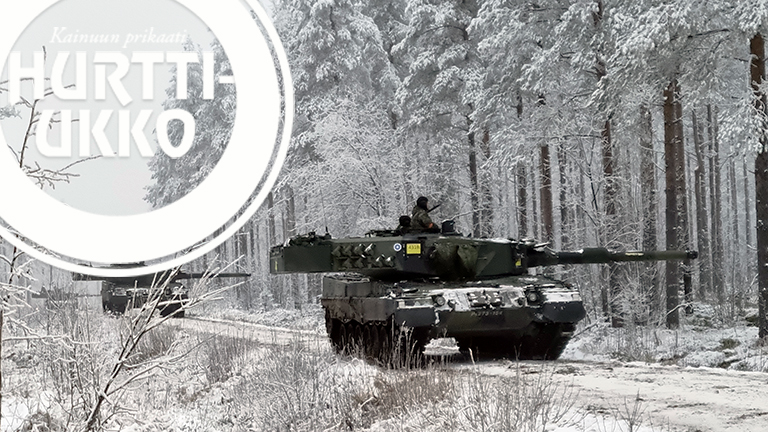 Kaksi panssarivaunua tiellä talvisessa metsässä.