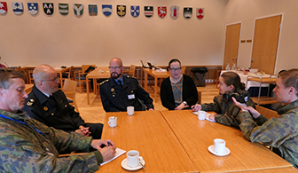 Sotilaat, poliisit ja siviili istuvat saman kahvipöydän ääressä