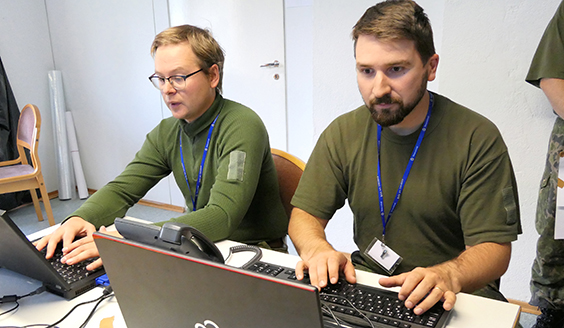 Kaksi sotilasta näpyttelevät tietokoneilla
