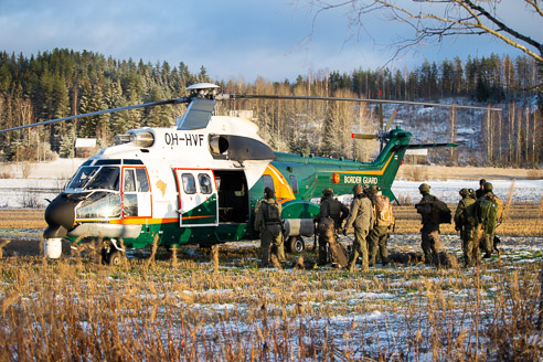 Maastopukuiset sotilaat kävelevät kohti helikopteria