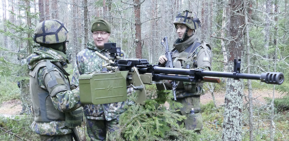 Upseeri keskustelee varusmiesten kanssa, vieressä ilmatrojuntakonekivääri