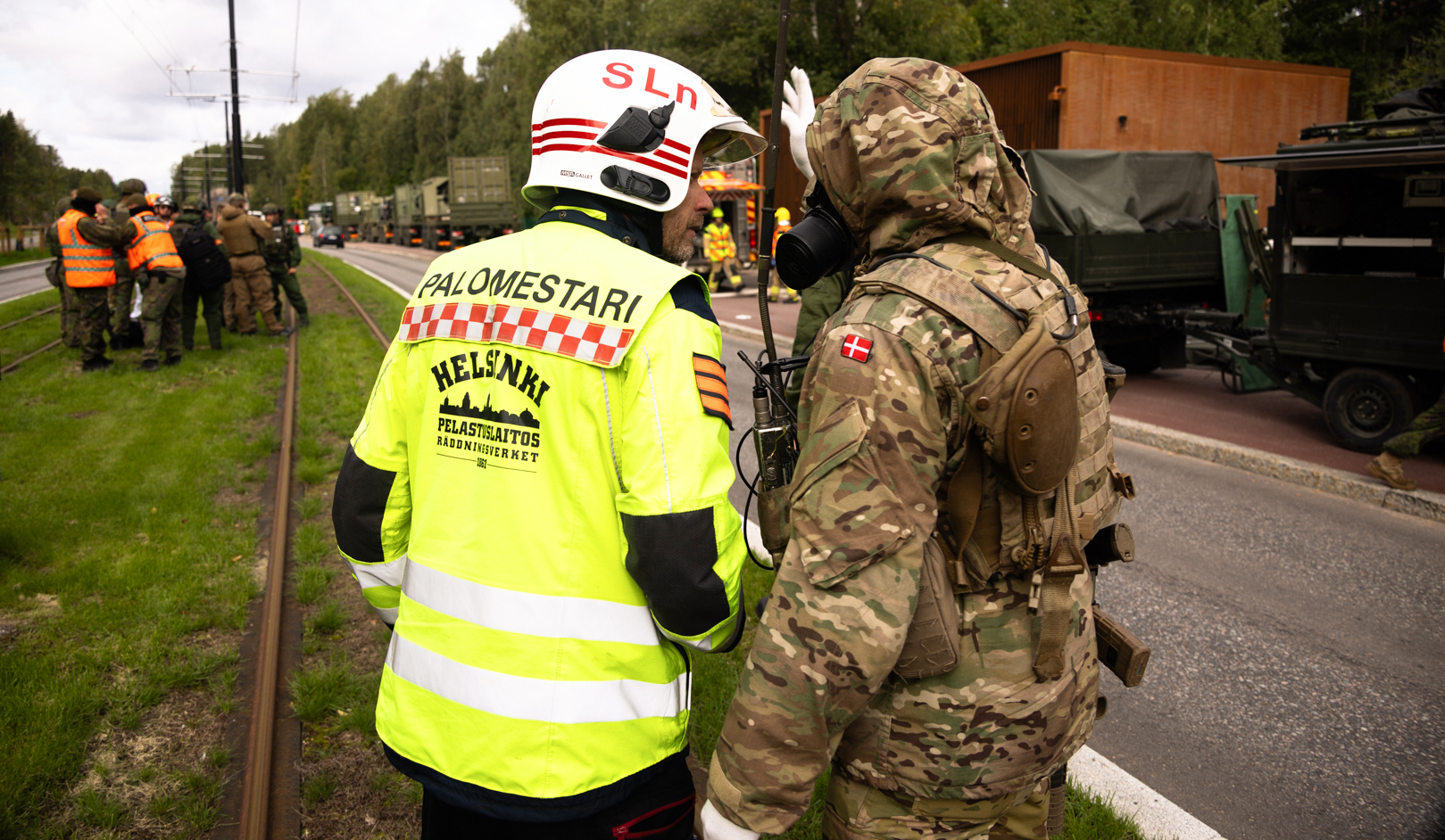 Kuvassa palomestari ja tanskalainen sotilas neuvottelemassa. Taustalla näkyy muuta harjoitusjoukkoa.