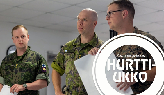 Suomalaisia ja amerikkalainen sotilas keskustelemassa toimistotilassa.