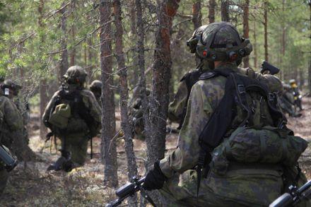 Sotilaita taisteluvarustuksessa metsässä