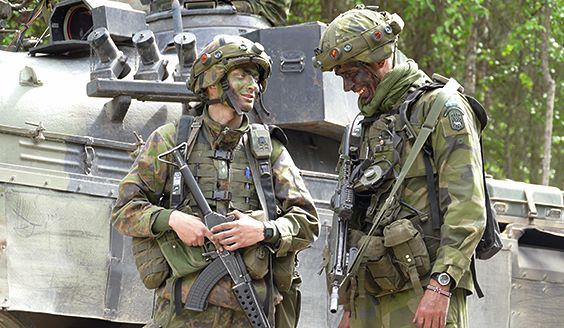 Kaksi sotilasta juttelee panssarivaunun vierellä
