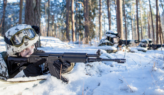 Soldiers aiming with assault rifles in winter terrain