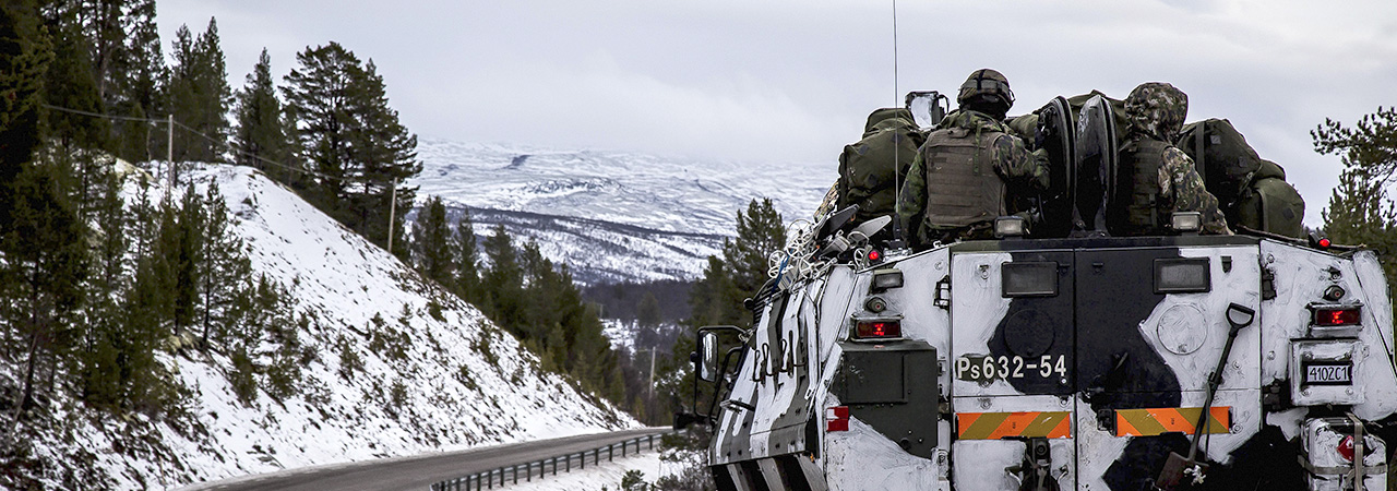 Miehistönkuljetuspanssarivaunu ajaa mutkaisia vuoristoteitä lumisessa maastossa