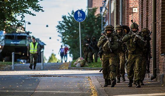 Sotilaat juoksevat kävelytiellä taisteluvarustuksessa