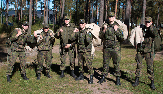 Sotilaat rivissä vaatesäkit selässä