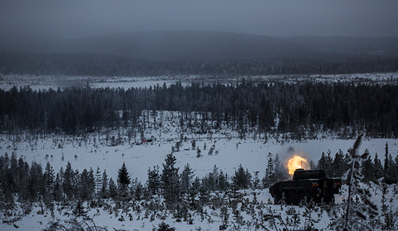 Tankki ampuu lumisessa metsässä
