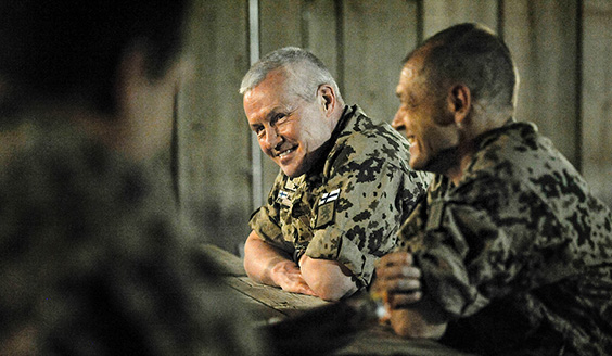 Kaksi sotilasta naureskelee pöydän ääressä