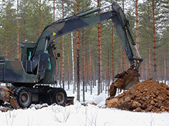 Kaivinkone kaivaa maata metsässä