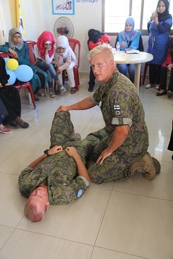 Sotilas havainnollistaa toisen sotilaan avulla siviileille