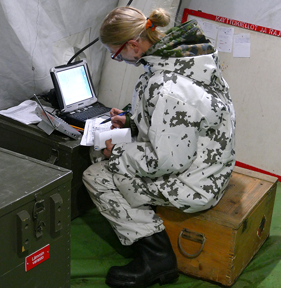 En kvinnlig soldat skriver anteckningar från en dator