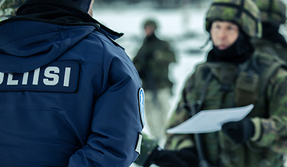 Sotilas ojentaa paperilappua poliisille