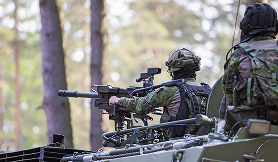  A soldier is aiming with a machine gun from the top of a tank