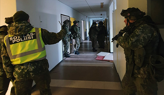 Maakuntakomppanian reserviläiset harjoittelevat sotilaspoliisireserviläisen johdolla kiinteistössä.